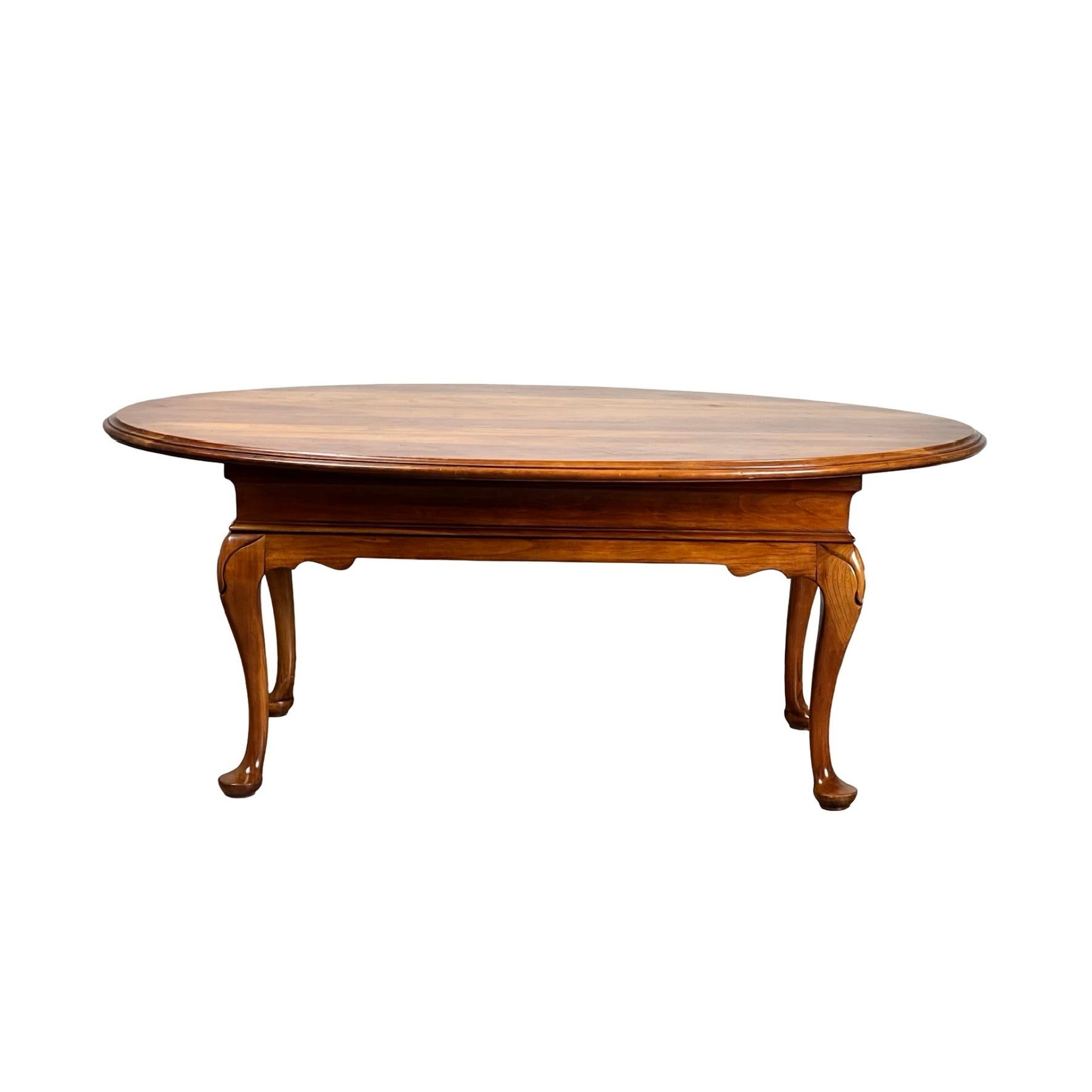 Vintage solid cherry Queen Anne style coffee table, attributed to Pennsylvania House, features a polished oval surface and curved legs, displayed against a white background.