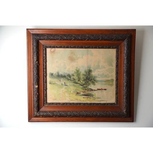 Antique Victorian Print of Tranquil Riverside Scene Signed S. A. Mullholland and dated 1897, offered by Pearl City Antiques, features trees, a rowboat, and two people standing on the riverbank; elegantly presented in an ornate brown wooden frame with carved details, this piece captures the charm of Victorian pastoral artwork.