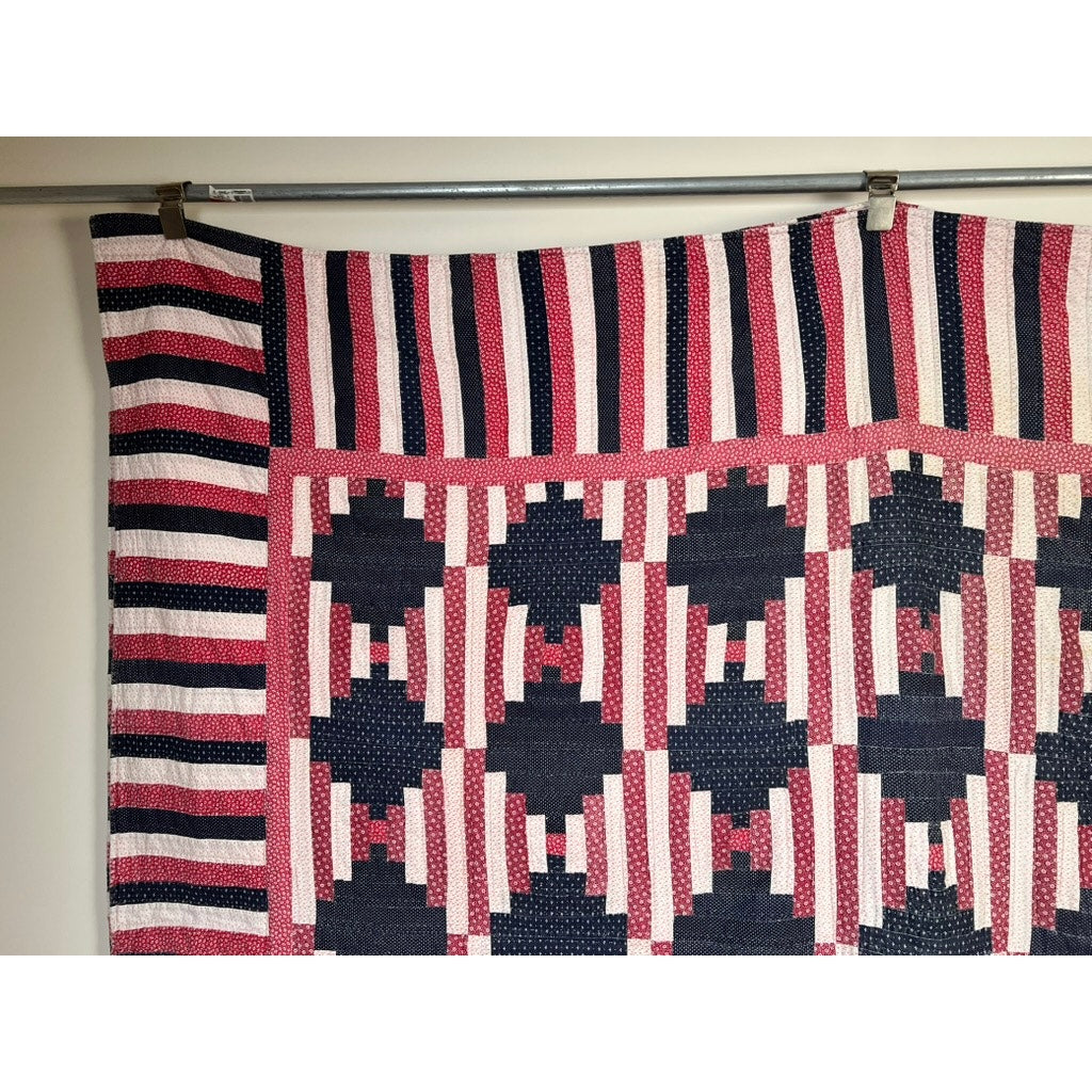 A matching pair of antique American hand-quilted Log Cabin quilts from the early 20th century features patriotic red, white, and blue hues, striped borders, and classic geometric patterns—perfect vintage Americana style.