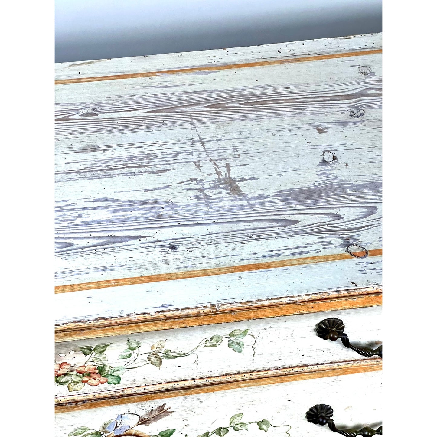 A close-up of this Antique Italian Paint Decorated Four Drawer Commode (c. Early 19th Century) shows weathered wood, peeling white paint, floral and bird motifs, ornate black handles, and aged details typical of provincial Italian furniture.