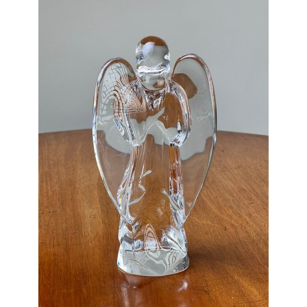 The Vintage Baccarat Crystal Angel by Baccarat, crafted in clear French crystal with outstretched wings, is displayed on a wooden surface against a plain gray background.