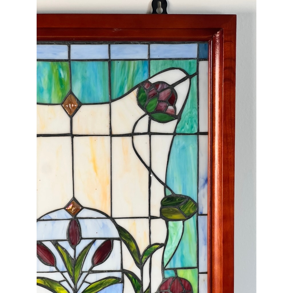 A close-up of the Vintage Stained Glass Wall Hanging 32x20 shows colorful geometric patterns, green leaves, and red flowers in a wooden frame, with blue, white, and green glass segments. Brand: None/Unknown.