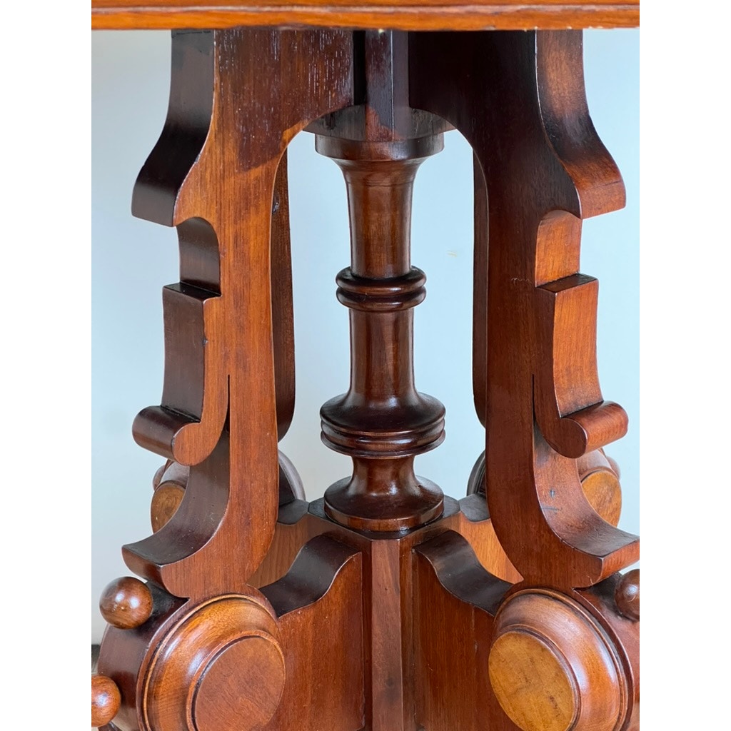 Close-up of intricately carved, dark walnut table leg with scrollwork and turned spindle, highlighting the craftsmanship and polished finish of this Antique Eastlake Victorian Walnut Marble Top Stand from the late 19th century.