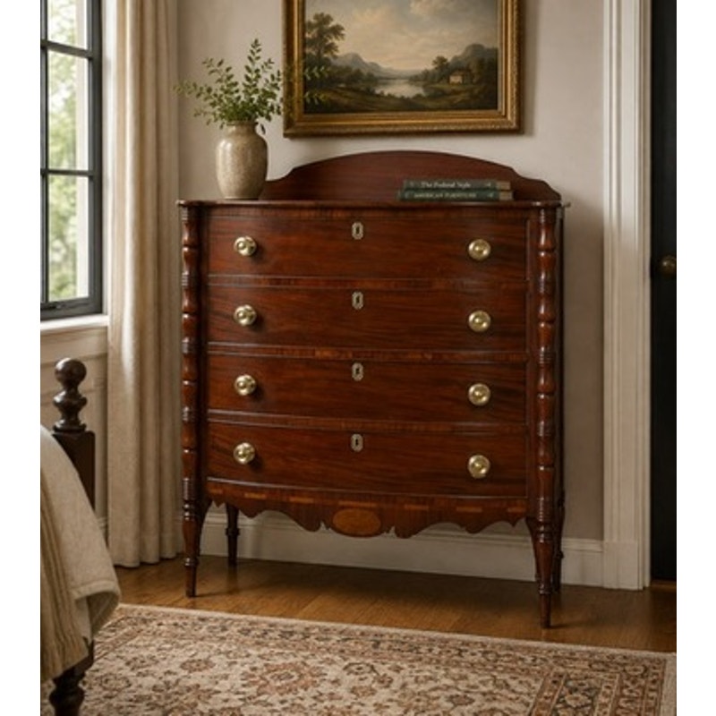 An Early 19th Century New England Federal Mahogany Bow-Front Chest of Drawers with Backsplash, c. 1820–1840 stands against the wall, adorned with a vase and books. Above it, a framed landscape painting is displayed beside a window, while a patterned rug partially covers the wood floor, recalling the timeless charm of antique craftsmanship.