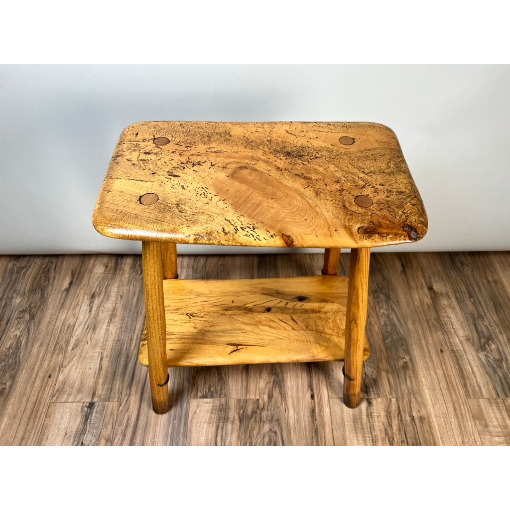 The Vintage Wabi Sabi Bench from Spalted Maple, signed by Neil Panyik, features unique natural grain and knots, evoking handcrafted artistry. Displayed on a wood-patterned floor against a plain light background. Brand: None/Unknown.