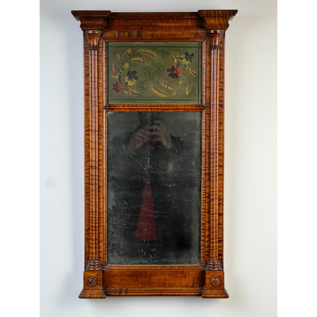 Fine Antique Federal Period Tiger Maple Two Panel Mirror c. 1820; features a rectangular frame, ornate columns, and decorative floral top panel. An early 19th-century American piece with a gently worn surface and faint reflection. Brand unknown.