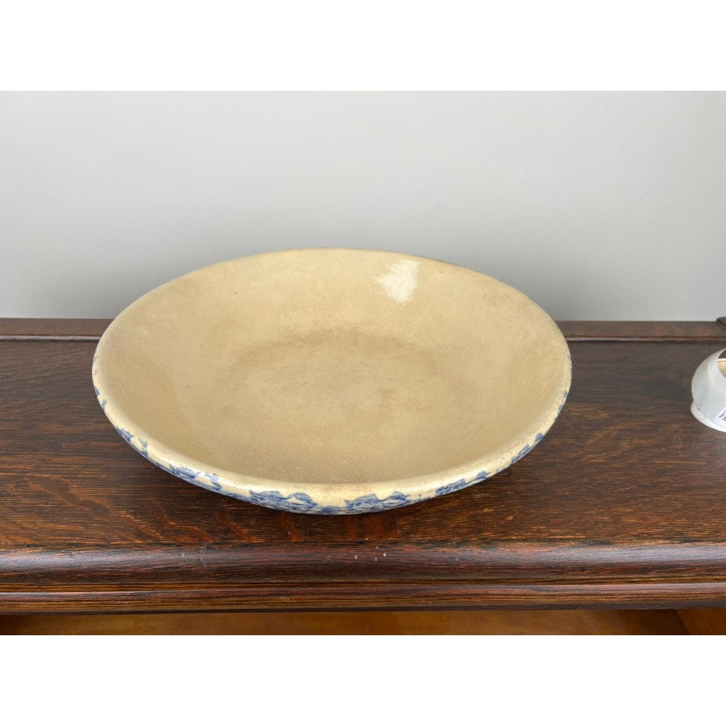 The Robinson Ransbottom Roseville Blue Spongeware Pasta Bowl by Robinson Ransbottom features a shallow, round beige ceramic design with a blue sponge pattern on the rim, evoking vintage American stoneware.