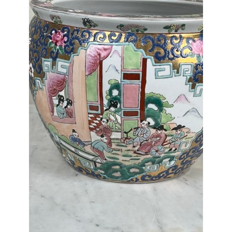 The Vintage Chinese Famille Rose Fish Bowl Signed Minicucci features intricate hand-painted scenes of figures in traditional dress amid trees, buildings, mountains, and floral and geometric patterns in blue, gold, pink, and green.