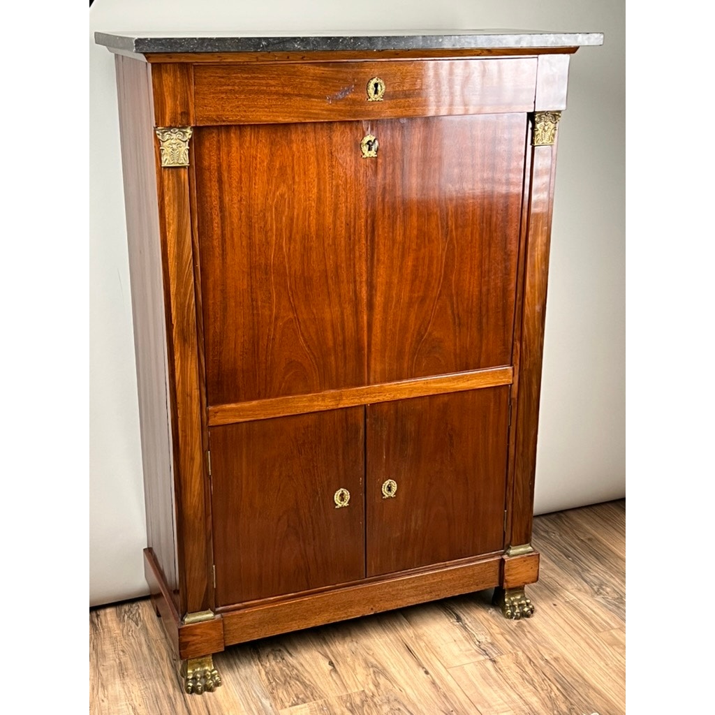 The Antique French Empire Secrétaire Abattant with Ormolu Mounts, c. mid-19th century, features a mahogany veneer, dark marble top, lion's paw feet, top drawer, drop-front compartment, and double doors below.