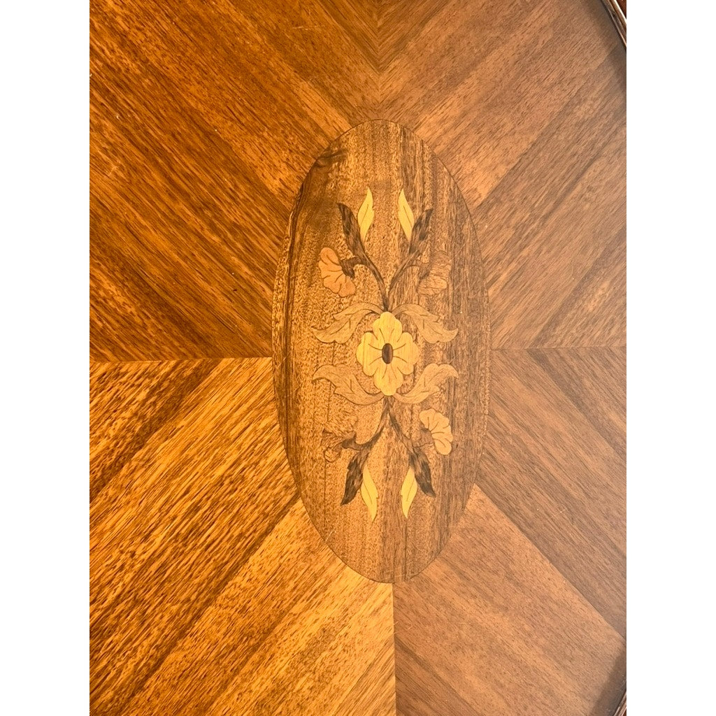 Close-up of a Vintage Louis XVI Style Butlers Table with a starburst pattern and oval centerpiece, featuring an inlaid floral design in contrasting wood tones; comes with a removable glass tray. Brand: None/Unknown.