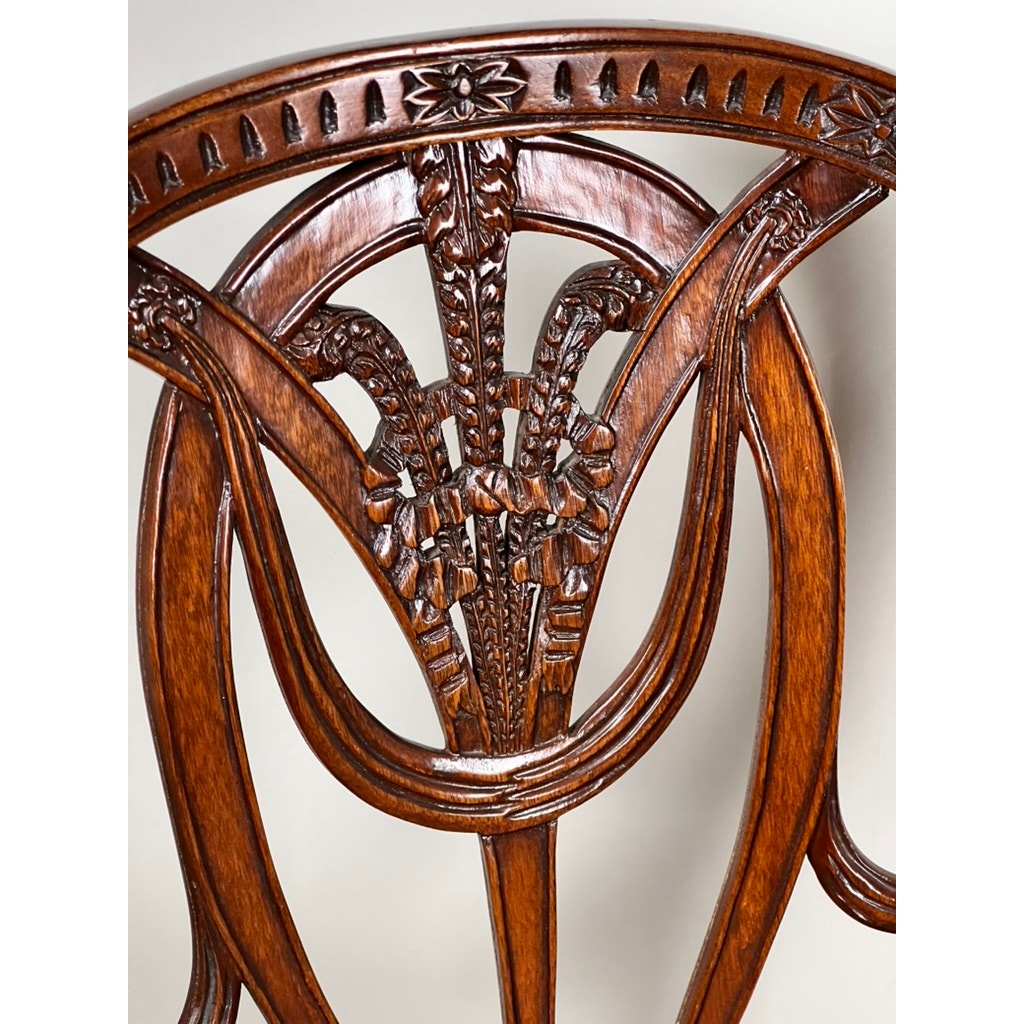 Close-up of a Vintage Pair Wheel Back Side Chair by Ardley Hall, highlighting its polished dark wood, floral and geometric patterns, and detailed craftsmanship with smooth curved lines.