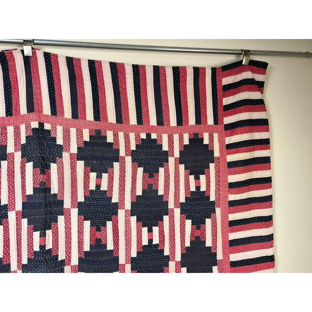 A matching pair of antique American Patriotic hand quilted Log Cabin quilts (early 20th c.) features red, white, and blue geometric patchwork and striped borders, echoing classic Americana designs found in vintage quilts.