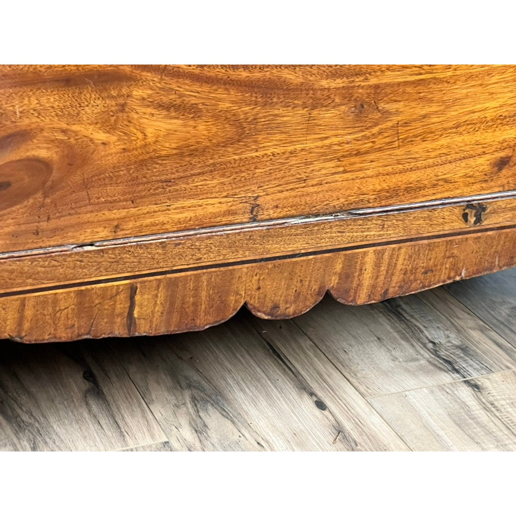 Close-up of the base of an Antique George III Two Over Four Chest with French feet (c. early 19th century), showing scalloped edge detail, visible wood grain, and wear, placed on a light-colored hardwood floor.