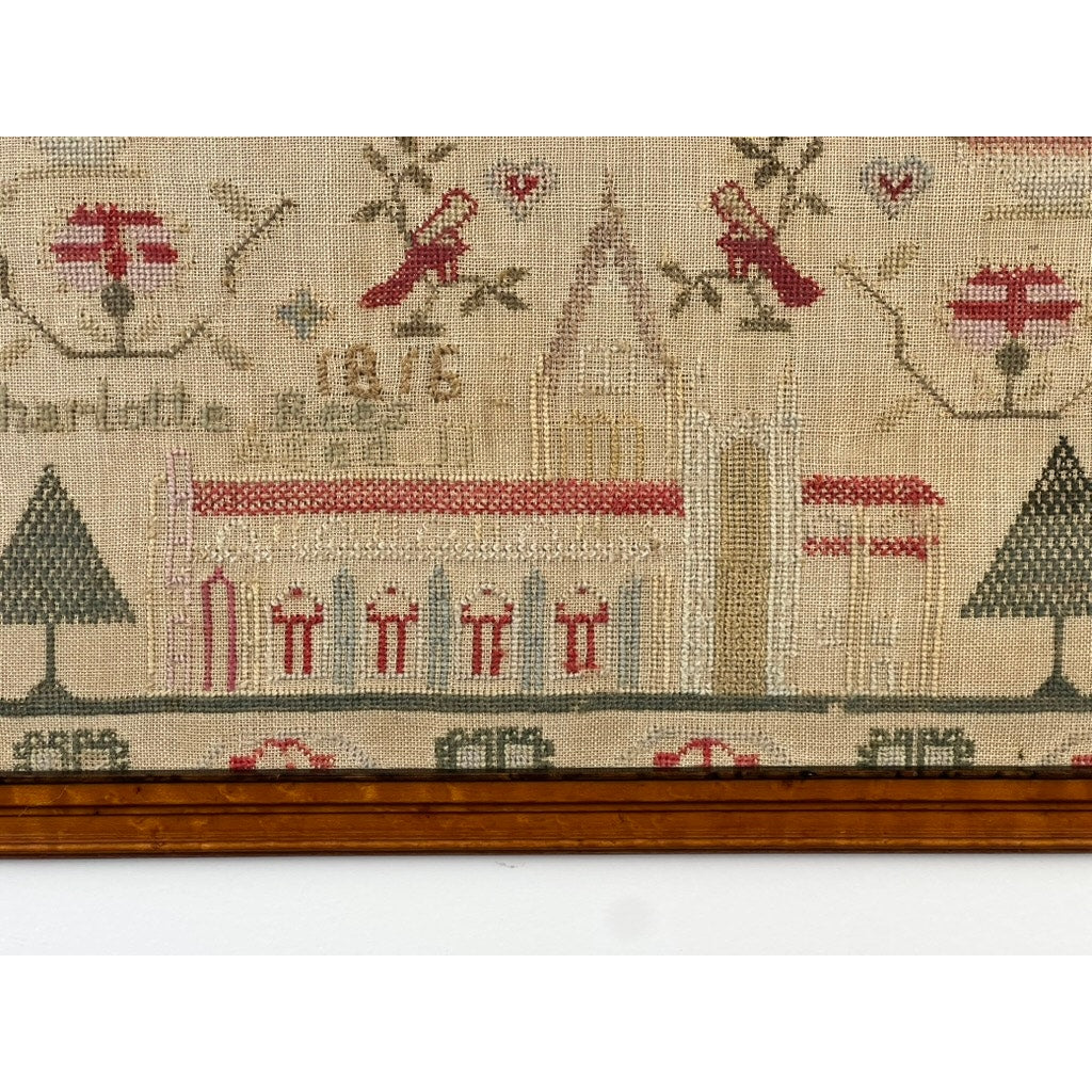 Exceptional English Regency Schoolgirl Needlework Sampler by Charlotte Rees, age 11, dated 1816. This charming sampler features a church with a tall spire, flanked by trees on either side, with vibrant red flowers and birds accenting the scene. Reminiscent of period samplers, the work is presented in a brown wooden frame. Brand: None/Unknown.