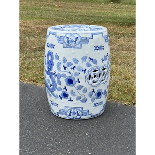 The Vintage Chinese Blue and White Porcelain Garden Seat features floral and geometric patterns, sitting on a paved surface with grass in the background, evoking classic charm. Brand: Unknown.