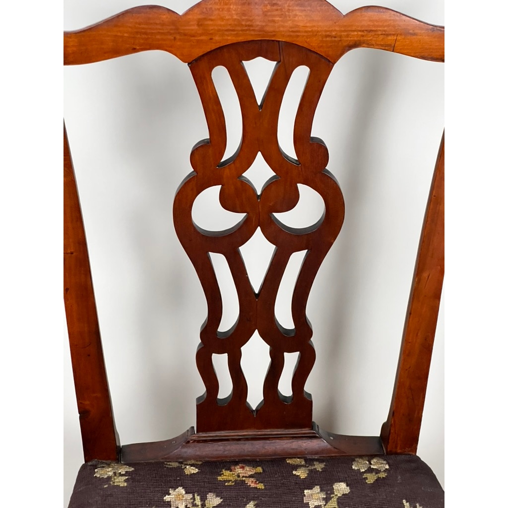 A close-up of the Antique Chippendale Side Chair with Needlepoint Seat c. Mid 19th Century shows its intricate cut-out back, floral needlepoint seat, polished wood finish, and classic English curved design. Brand: Unknown.