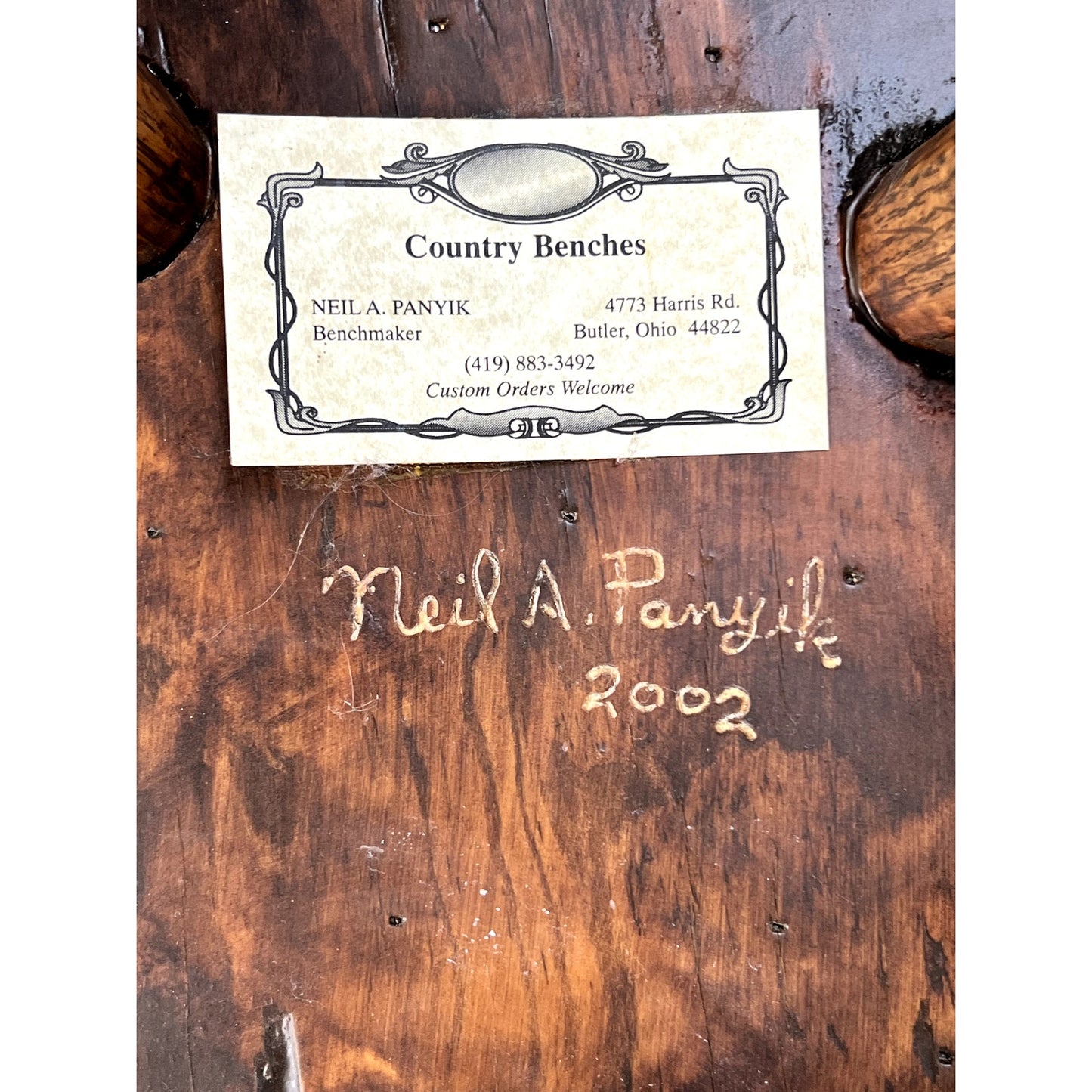A business card is shown above a wood surface signed Neil Panyik, 2002. The card features “Custom Orders Welcome” and contact info, promoting the Pair Vintage Live Edge Wabi Sabi Cherry Stools signed by Neil Panyik (brand unknown).