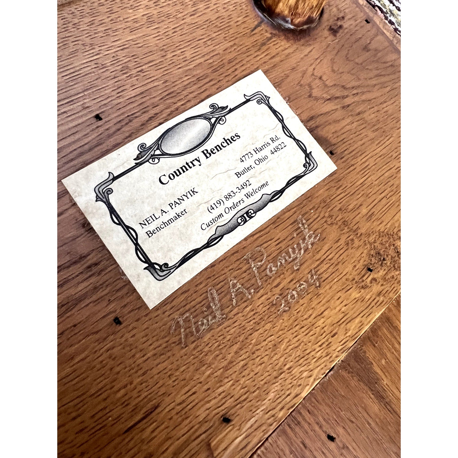 A business card for “Vintage Wabi Sabi Bench from Spalted Maple signed Neil Panyik” is attached to a wooden surface engraved with “Neil Panyik 2024,” featuring contact info for this handcrafted furniture maker from Bowling Green, Ohio.