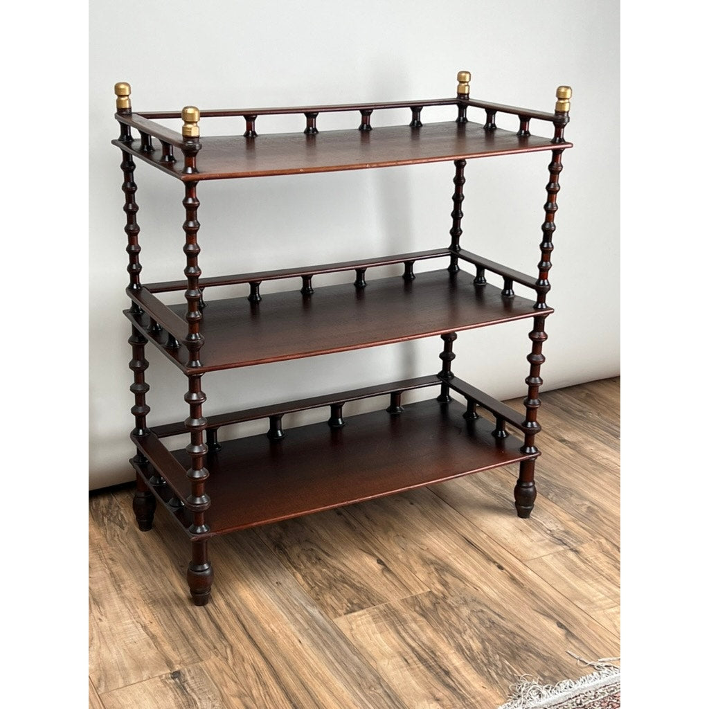 A Vintage Bobbin-turned, Three Shelf Wooden étagère or Whatnot stands on a wood floor against a light-colored wall, showcasing wooden spindles and classic turned details.