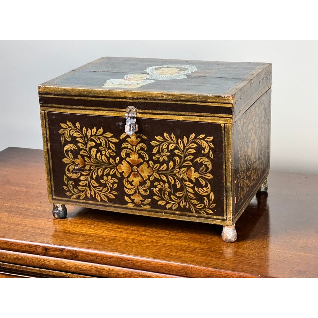 An Antique New England Folk Art Painted Portrait Document Box, Mother & Child, c. 1840–1860, features hand-painted details and sits on a polished wooden surface, reflecting mid-19th century American decorative style.