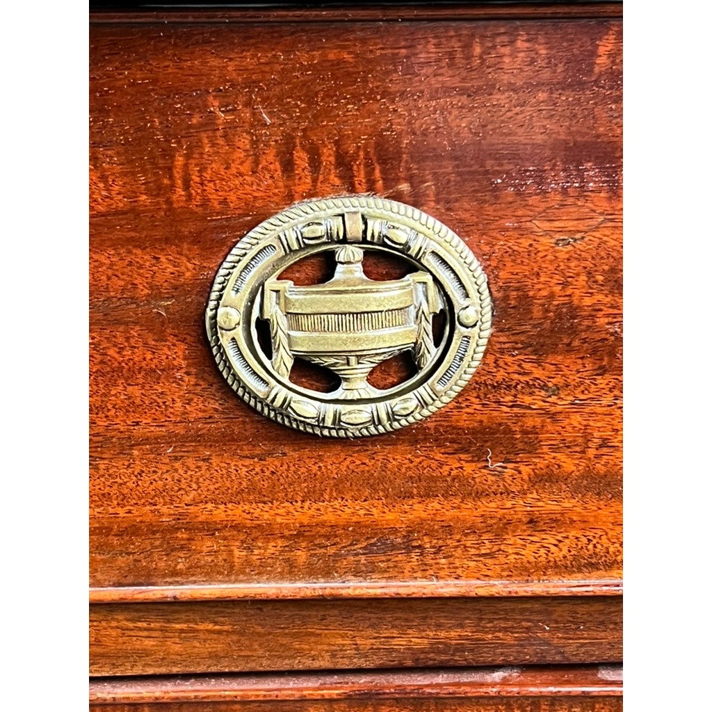 A close-up of an ornate, round brass drawer pull with a basket design on the polished surface of an Antique Directoire Style French Cylinder Desk with Slate Top, dating to the late 19th century and featuring a rich reddish-brown finish.