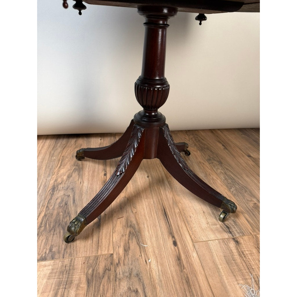 An Early 19th Century New York Classical Mahogany Astragal-End Work Table in the manner of Duncan Phyfe (c. 1815–1825) stands on a light wood floor against a plain white background. The elegant mahogany pedestal base, featuring four carved legs that end in brass casters, exemplifies the refined craftsmanship associated with early 19th-century parlor furniture.