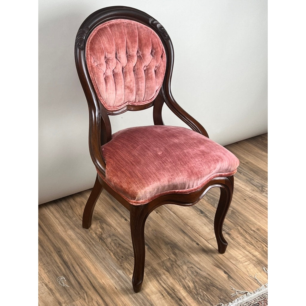 An Antique Victorian Walnut Tufted Balloon Back Side Chair (late 19th century), with a curved frame, pink tufted velvet backrest, and matching seat cushion, stands on a wooden floor against a plain wall. Brand: Unknown.