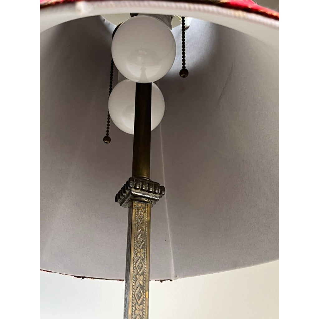 Close-up of the Antique Art Deco Cast Iron Floor Lamp by Rembrandt, featuring two white bulbs, ornate brass pole, pull chains, and a white lampshade with red trim. The sturdy cast iron base enhances its vintage Rembrandt charm.