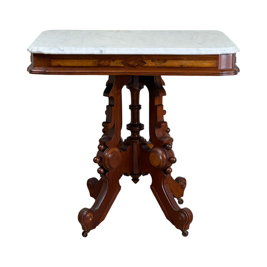 Antique Eastlake Victorian Walnut Marble Top Stand, late 19th century, features a white marble surface and ornate carved walnut legs and sides. The stand, brand unknown, is shown against a plain white background.