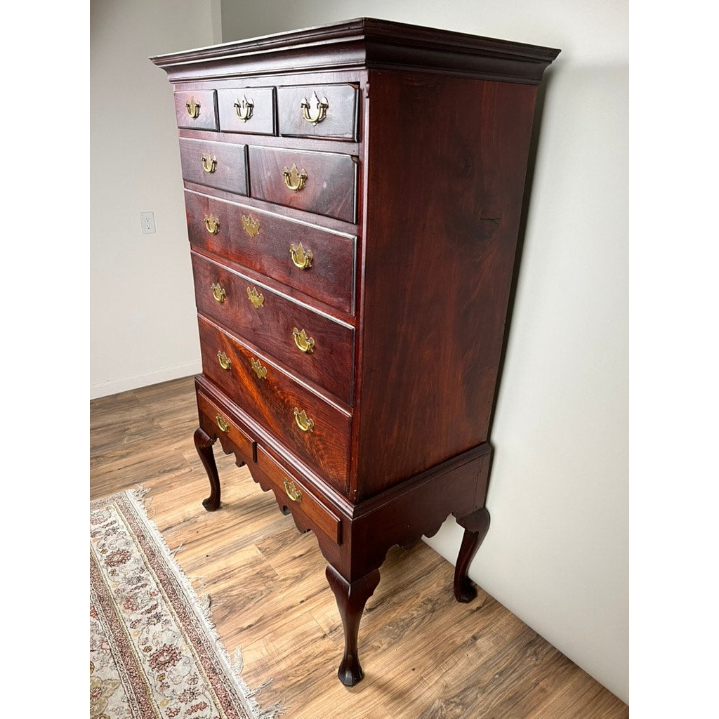 An Antique Queen Anne Walnut Chest on Frame with drake feet, probably Irish from the late 18th century, stands on a hardwood floor beside a patterned rug in a well-lit room.