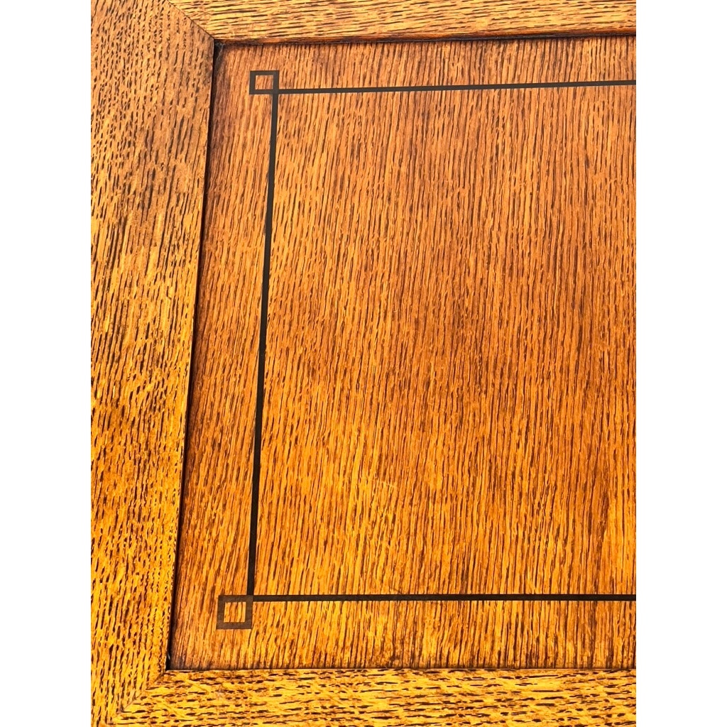 Close-up of the Stickley Vintage Harvey Ellis Millennium Edition Oak Blanket Chest showcases fine oak grain, a rectangular border with square corners, and a warm golden-brown finish, echoing classic Arts & Crafts design.