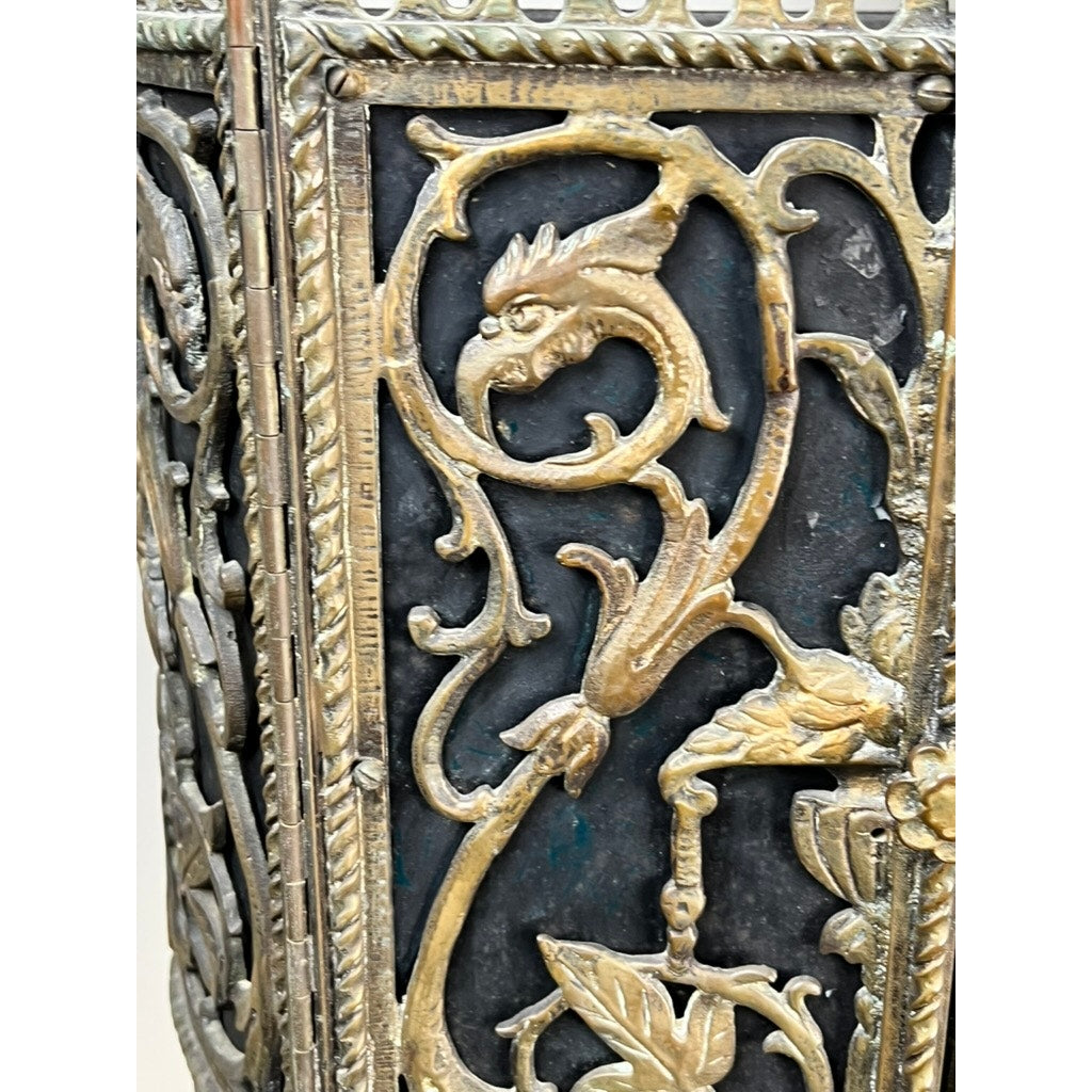 Close-up of an Antique Gothic Revival Cast Iron and Brass Phone Stand, attributed to Oscar Bach or Bertram Segar c. 1920 Greenwich Village, featuring ornate gold-toned dragon motifs and curling vines on a dark background. Brand: Unknown.