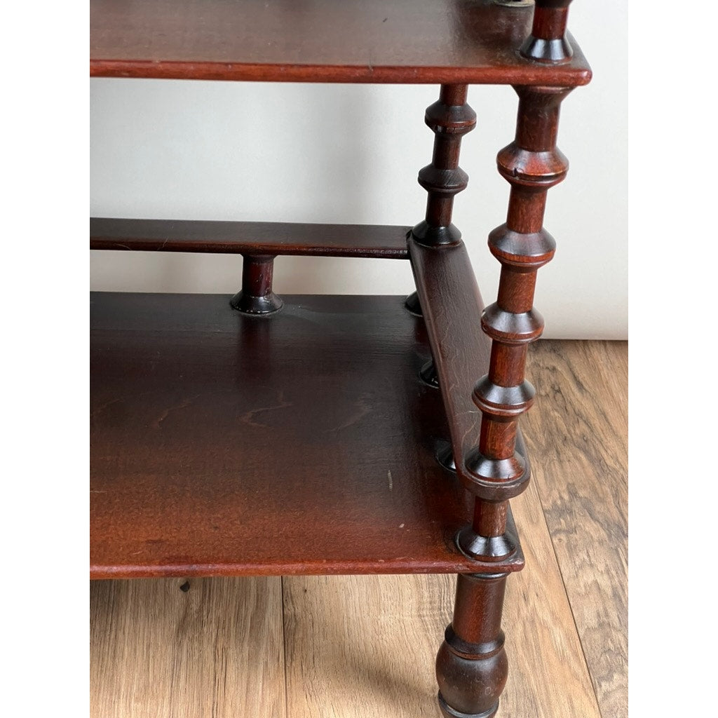 A close-up of a Vintage Bobbin-turned, Three Shelf Wooden étagère or Whatnot with rich brown wood grain and turned legs is shown on a light wood floor. Brand: None and/or Unknown.