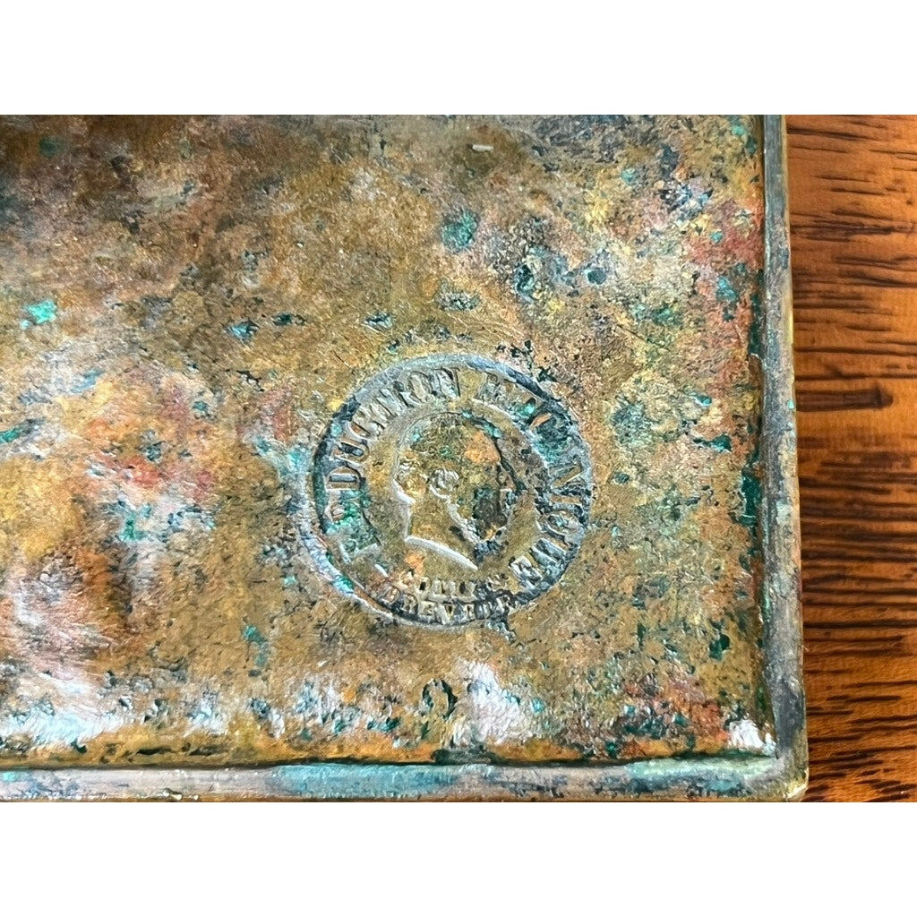Close-up of a weathered Jean-Baptiste Clesinger “Taureau Romain” bronze sculpture, stamped Barbedienne Foundry, Rome 1858, showing a profile and partial text on the corner of a rectangular base resting on wood.