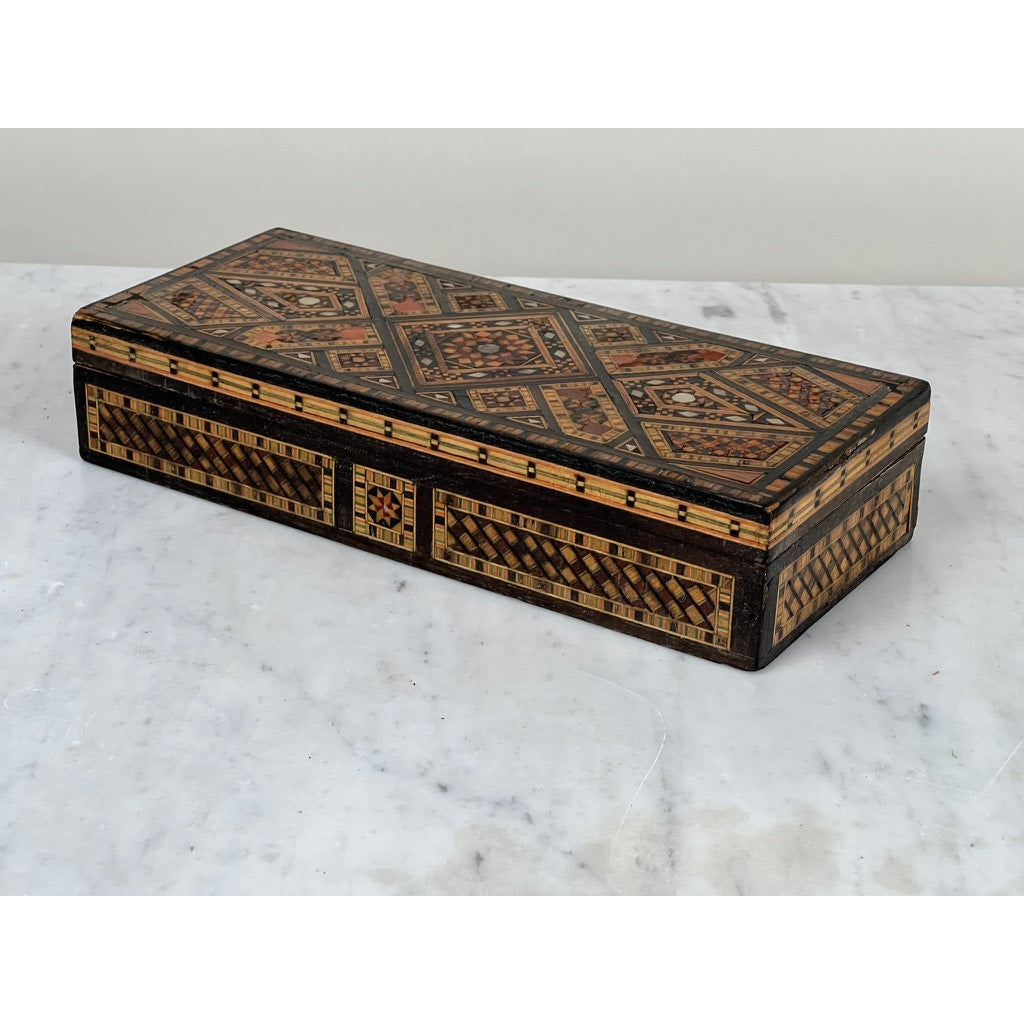 An Antique Persian (likely Syrian) Khatam Inlaid Wood Jewelry Box, early 20th century, with intricate geometric and mosaic designs in brown, black, and tan, shown on a white marble surface.