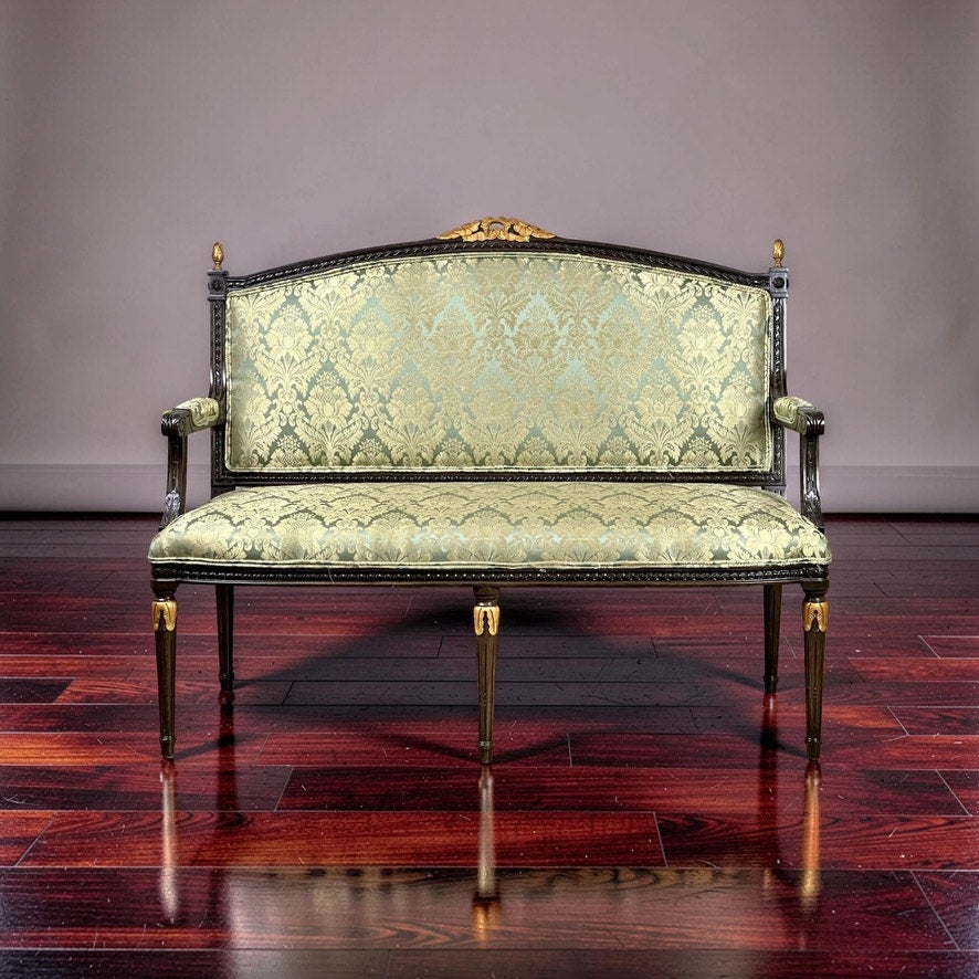 A Vintage Louis XVI Style Settee in Green Damask Upholstery sits on a polished dark hardwood floor against a plain gray background. Brand name is unknown.