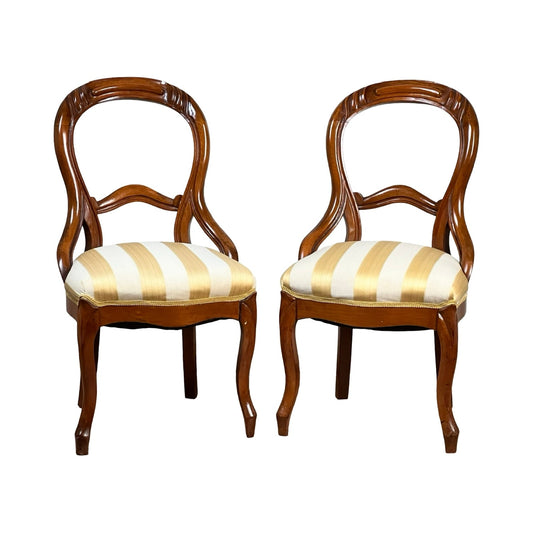 A Pair Antique Victorian Balloon Back Chairs (late 19th century) with ornate, curved backs and yellow-and-white striped cushioned seats, shown side by side against a white background. Brand is unknown.