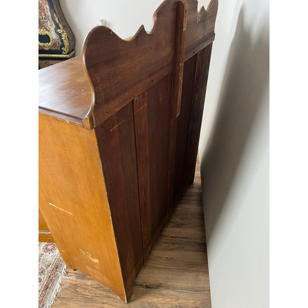 An Antique Victorian Grain Painted Country Jelly Cupboard c. 1870 stands on a wood floor by a white wall. The visible grain and light scratches add charm, with part of a patterned rug and upholstered furniture in the background. Brand unknown.