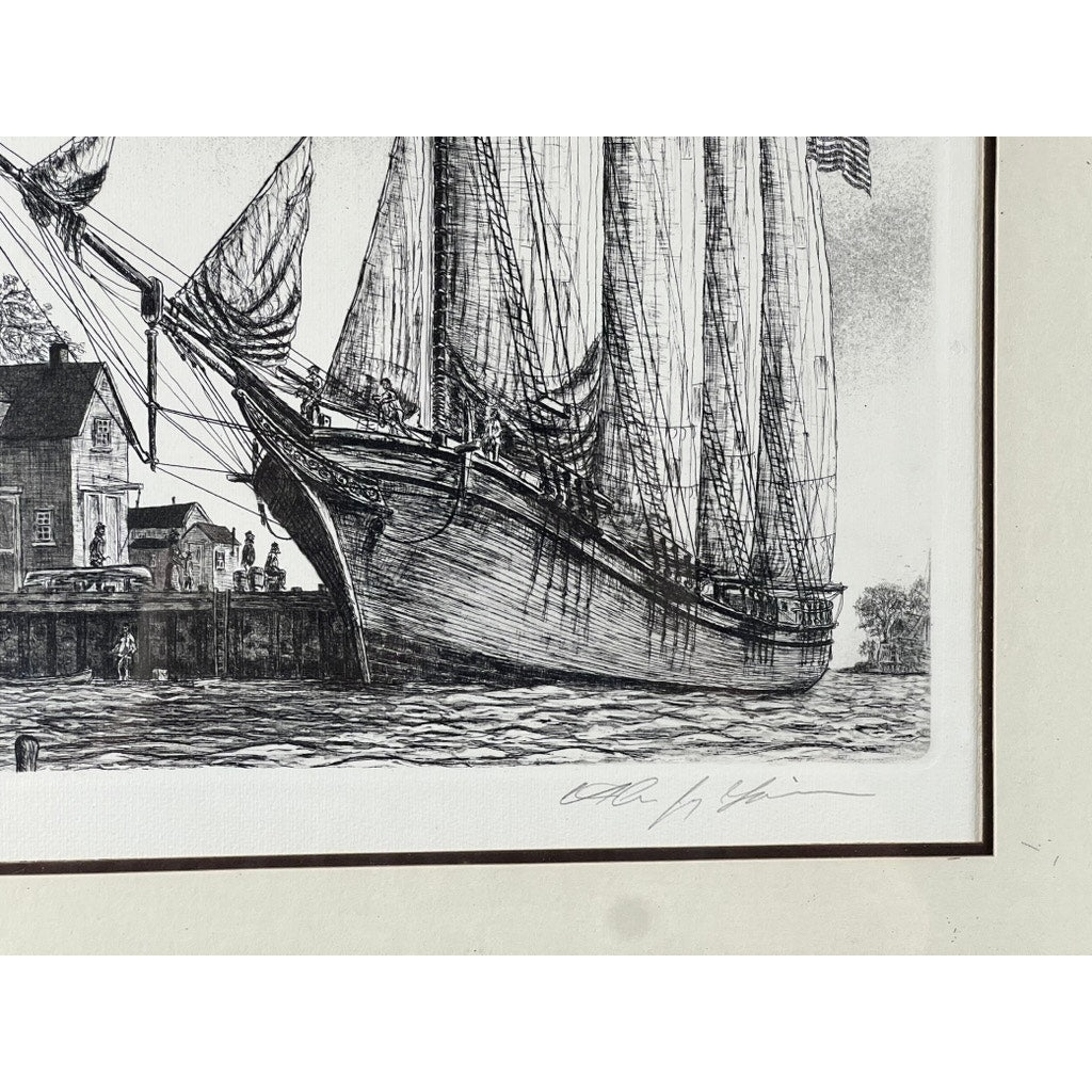 Framed Etching “The Schooner” by Alan Jay Gaines: black-and-white maritime scene of a large sailing ship docked near buildings, with masts and rigging; artist’s signature in pencil on the white border below.