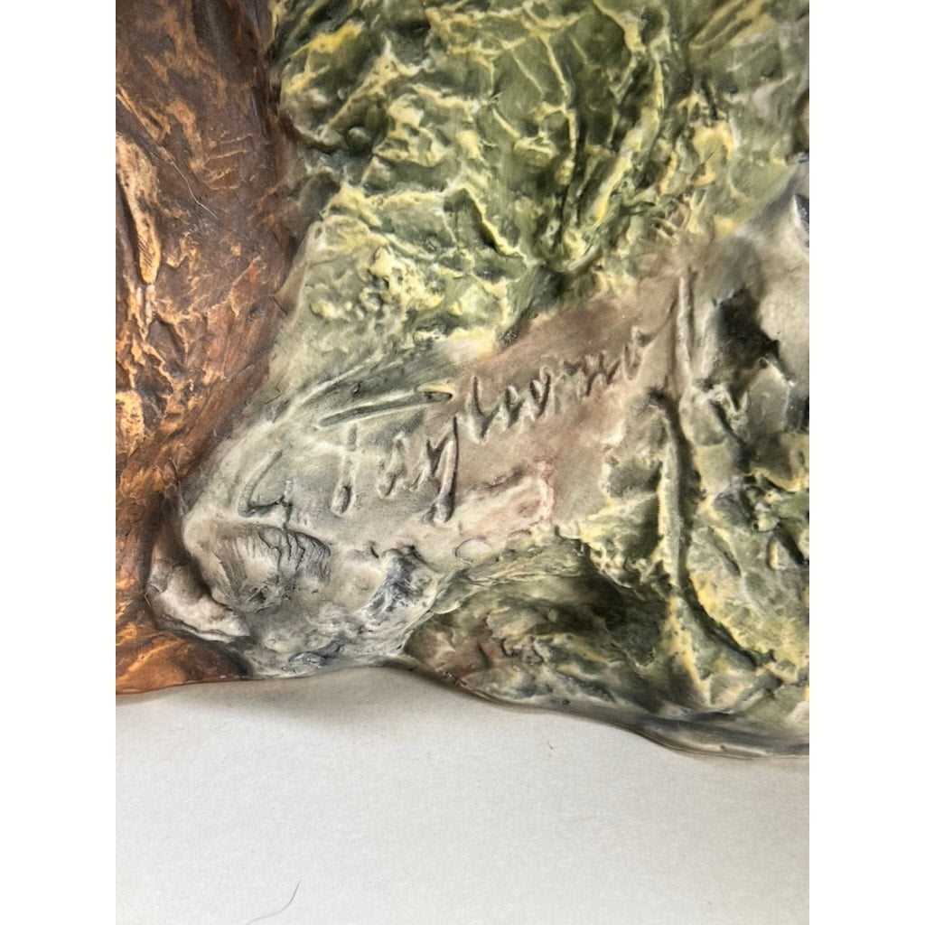 A close-up of the textured, multicolored surface of the Rare Kaiser Porcelain American Bald Eagle Sculpture (Limited Edition No. 12/200, W. Germany) with engraved signature, featuring green, brown, and beige tones.