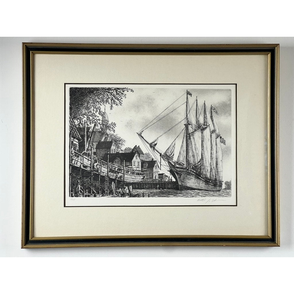 Framed Etching “The Schooner” by Alan Jay Gaines—black and white maritime art depicting a large sailing ship docked by old buildings, with people on the pier and trees in the background. Brand: Unknown.