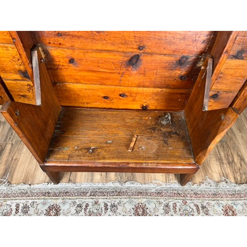 The Antique Country Pine Hutch Table with Six Plank Top c. 18th Century is shown open to reveal storage, its worn wood and scratches evoking historic charm. A patterned rug appears partially beneath it. Brand: None/Unknown.