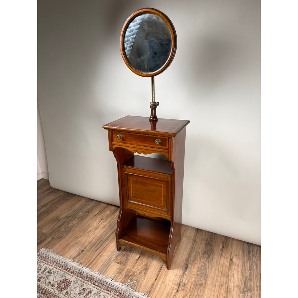 An Antique English Mahogany Inlaid Shaving Stand with Adjustable Mirror, c. 1880–1900, featuring a small drawer, an open storage compartment, a bottom shelf, and an adjustable oval mirror on a central pole.