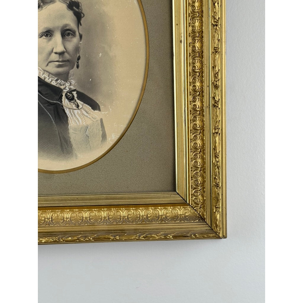 Close-up of the Antique Civil War Era Portrait of a Woman in a gilt wood frame, revealing the upper left with part of her face and torso. Intricate gold detailing contrasts beautifully against a light wall. Brand: Unknown.
