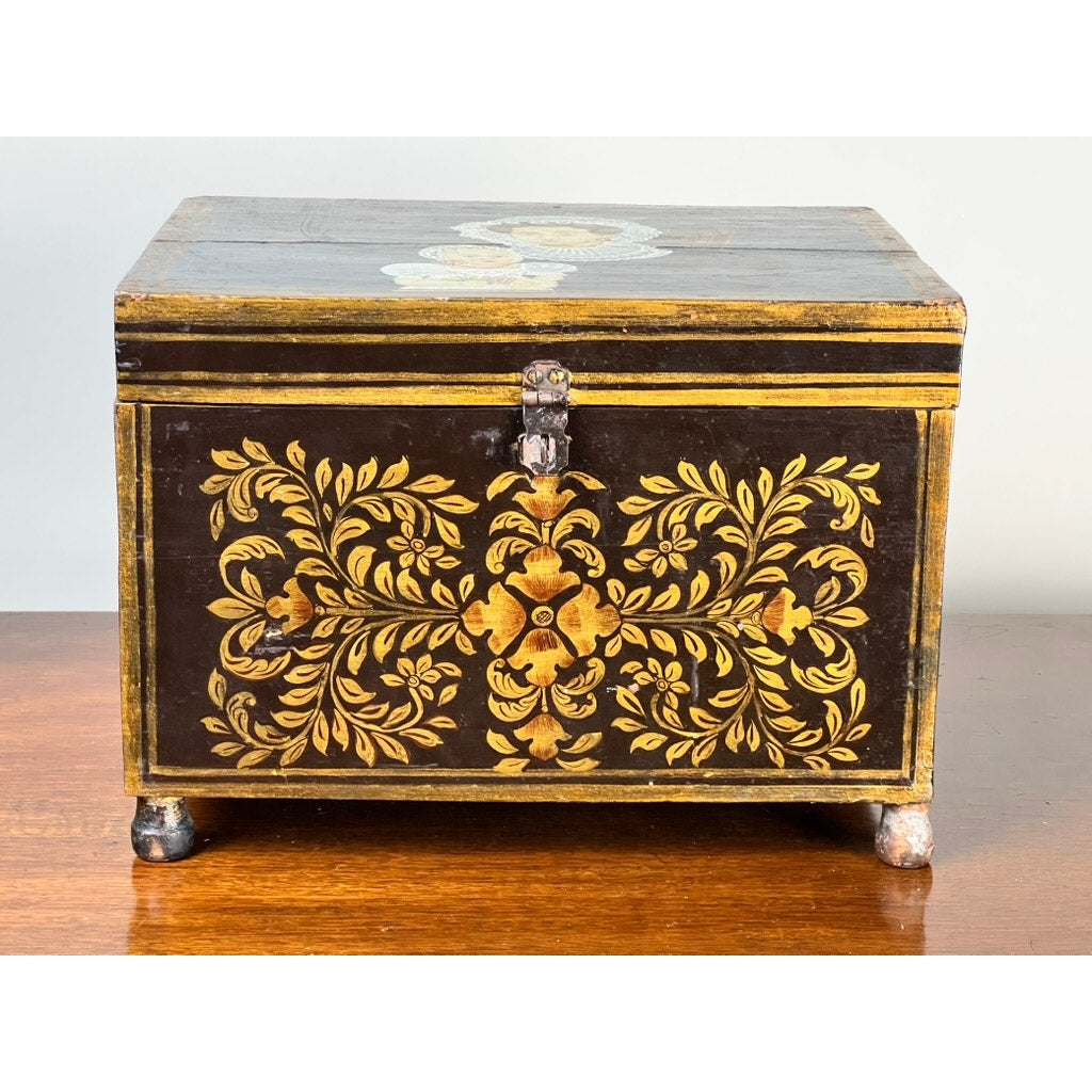 The Antique New England Folk Art Painted Portrait Document Box (c. 1840–1860) features a hand-painted mother and child, intricate floral details on dark wood, a front latch, and small legs, reflecting mid-19th century American decorative art.