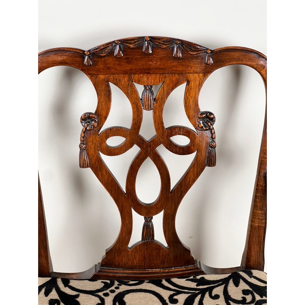 Antique George III Chippendale Open Arm Chair (early 19th century) with intricate carved wooden back, tassel-shaped details, and curving lines. Classic English style; patterned fabric seat partially visible against a plain light background. Brand unknown.