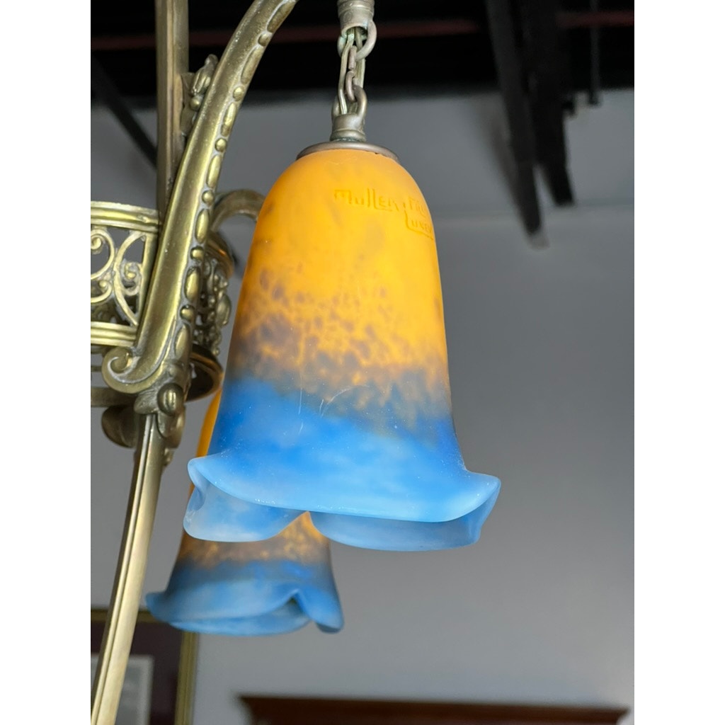 Close-up of a Vintage Muller Frères Lunéville French Brass and Art Glass Four Light Chandelier with bell-shaped shades, featuring yellow-to-blue gradients, and ornate metal fixtures—classic vintage French design.