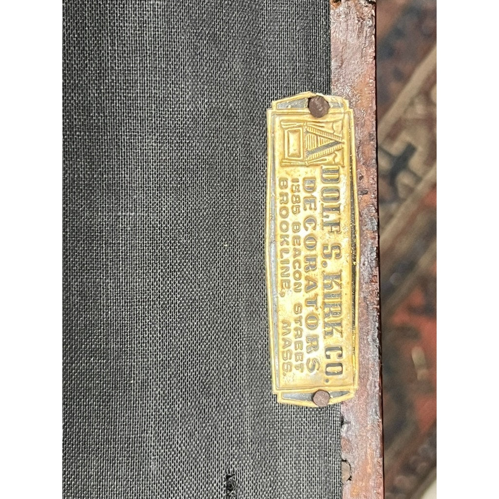 A brass nameplate reading “ADOLF S. ARLICO LUGGAGE STORES 1336 BEACON STREET BROOKLINE, MASS” is affixed to a dark surface, with an Antique Chippendale Side Chair with Needlepoint Seat c. Mid 19th Century in the background.