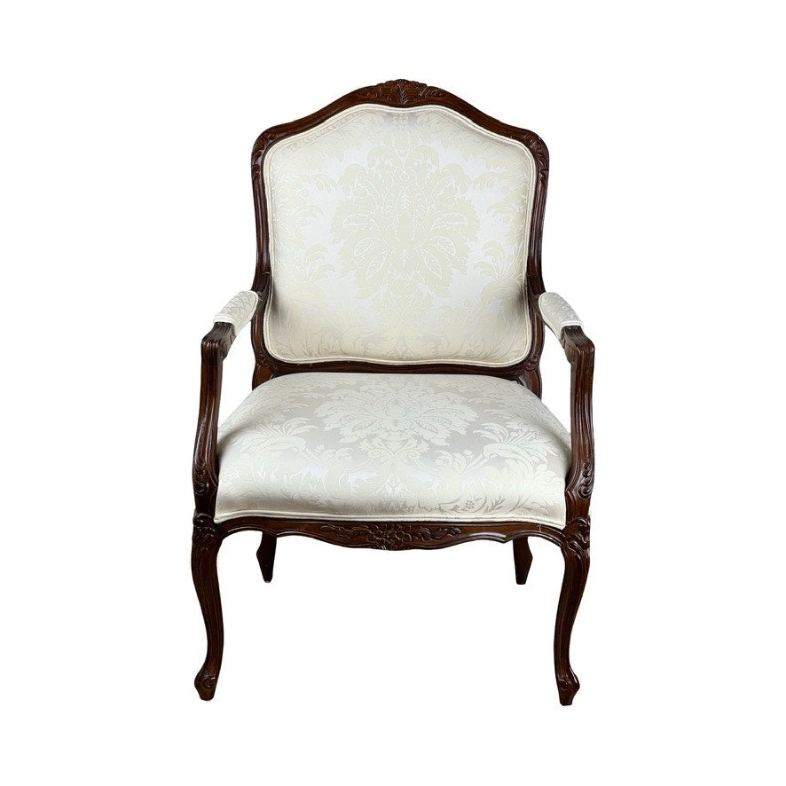 A Vintage Louis XV Style Fauteuil Arm Chair by Pennsylvania House, featuring a carved dark wood frame and cream damask upholstery, is shown from the front against a white background.