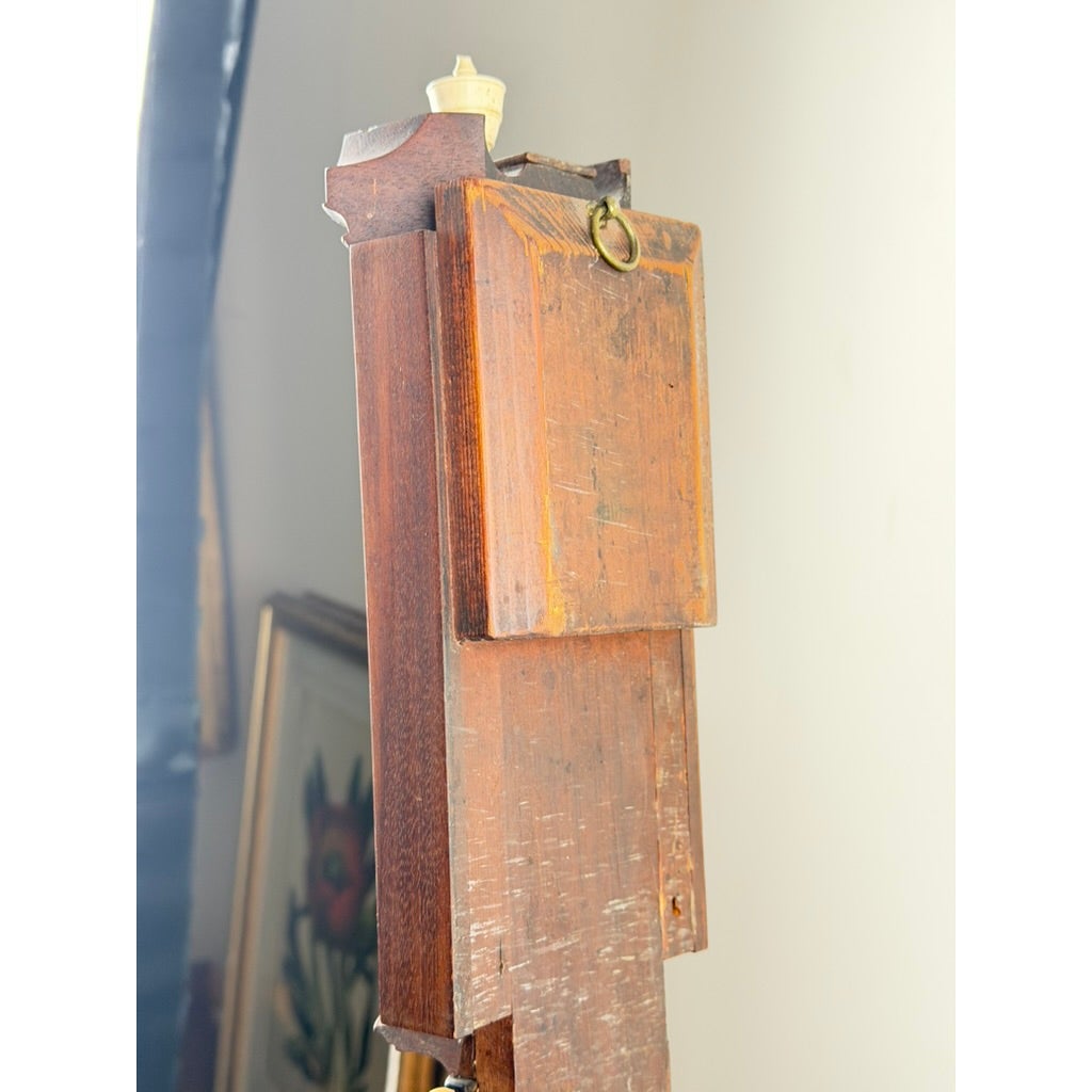 The back of an English Regency Mahogany Stick Barometer by Thomas Jones, Liverpool, c. 1820, an antique wooden stick barometer featuring a small metal hanging ring at the top.